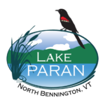 An oval with a graphic image of a red-wing blackbird sitting on top and a cattail plant on the left. In the center the words "Lake Paran" and under the oval "North Bennington, VT"