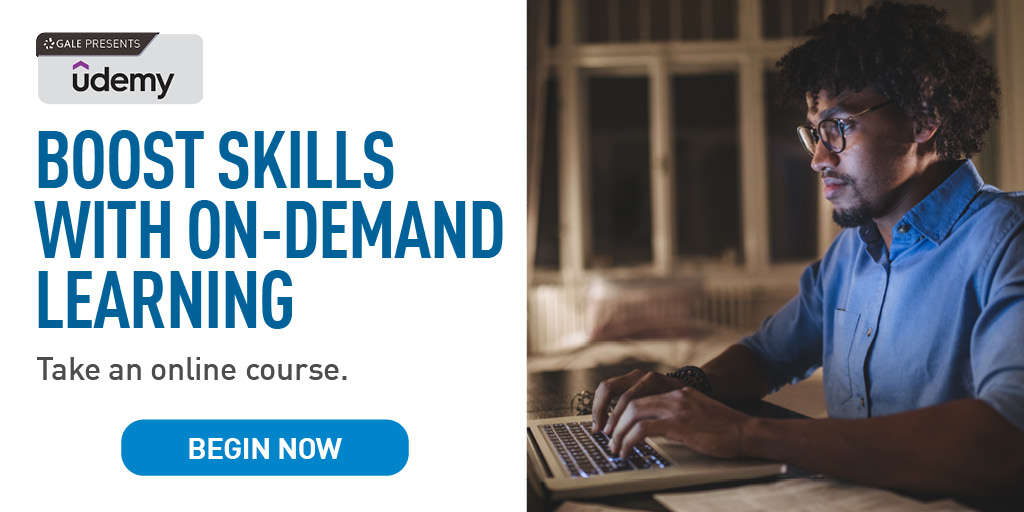 An image of a man working on a laptop at night takes up the right hand side of this image. The left hand side is a white background with black and blue text that reads: "Boost Skills with On Demand Learning. Take an online course." This text sits between the Udemy logo and a blue button that says Begin Now.